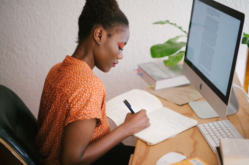 A writer reviewing content drafts on a laptop at a cafe workspace
