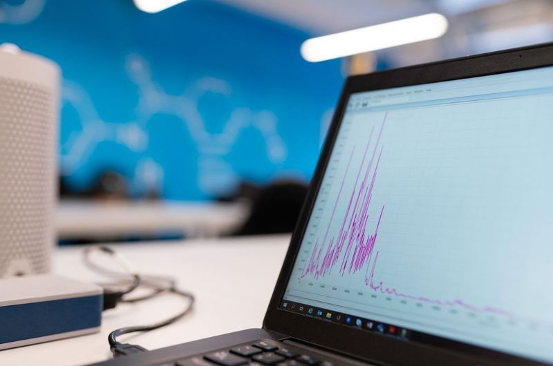 A laptop displaying analytics data and growth graphs used to measure conversion optimization results