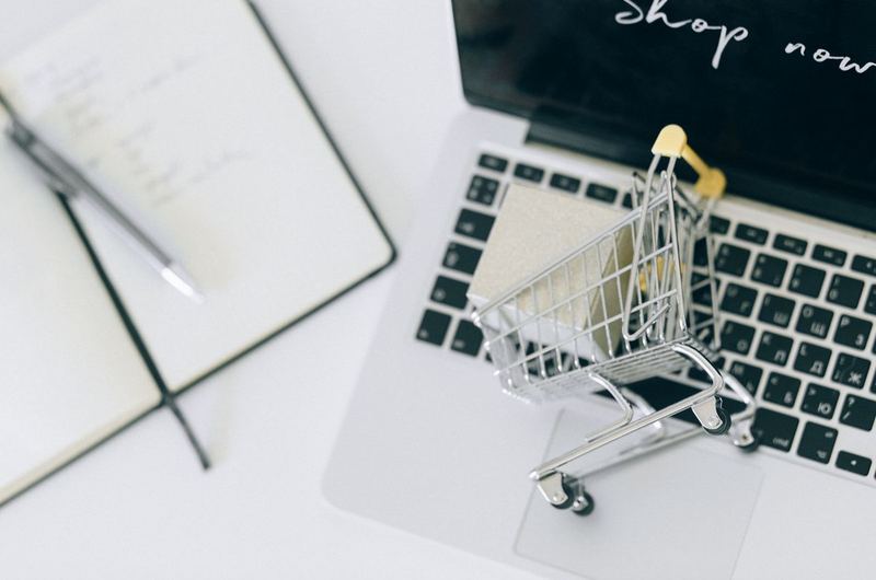 A miniature shopping cart on a laptop keyboard, symbolizing the online transactions that ecommerce SEO drives