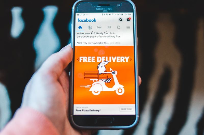 A smartphone displaying a social media advertisement, showing how businesses reach customers through paid social