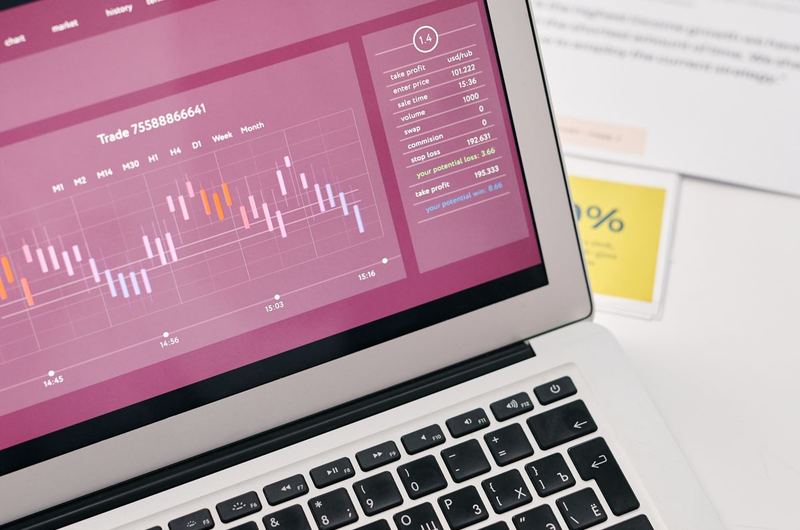 A laptop showing data graphs and analytics reports similar to Google Analytics dashboards