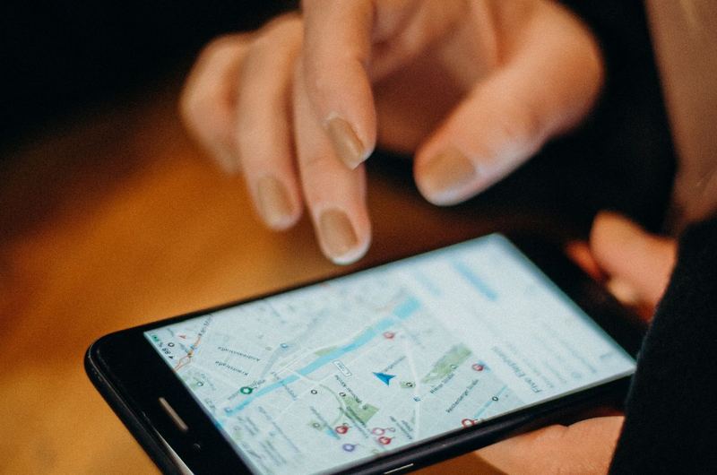 A person using a map application on their smartphone to find a local business listing