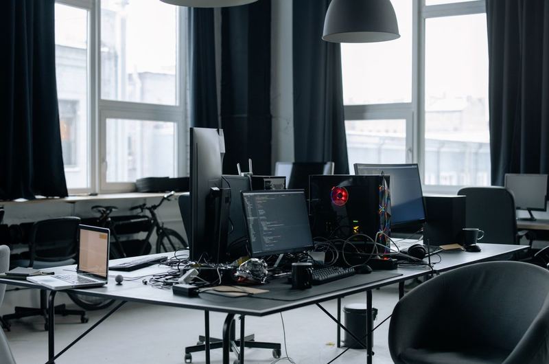 A technology workspace with multiple screens and code, typical of the IT companies that benefit from tech SEO