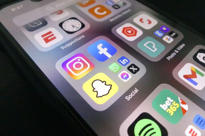 A smartphone showing social media apps where Open Graph tags control how shared links appear