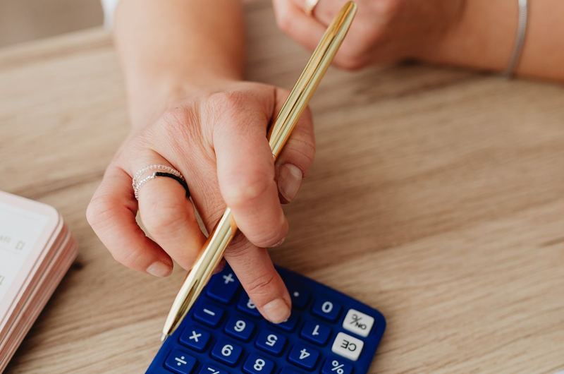 A person using a calculator for financial planning, representing salary and compensation research