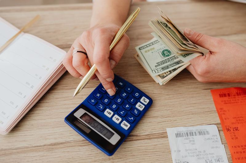 A person calculating costs and reviewing receipts, similar to budgeting for a website project