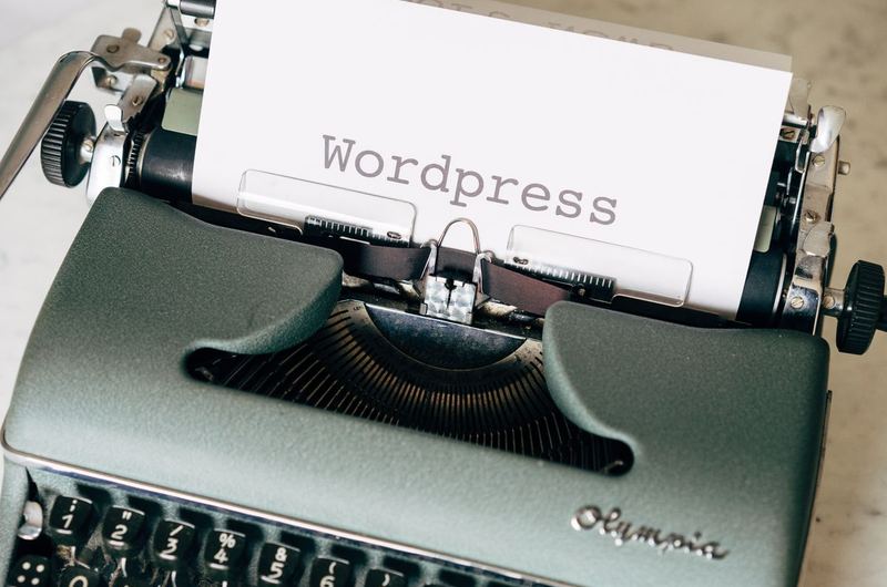 A typewriter with WordPress typed on paper, representing the popular CMS option in the website platform decision