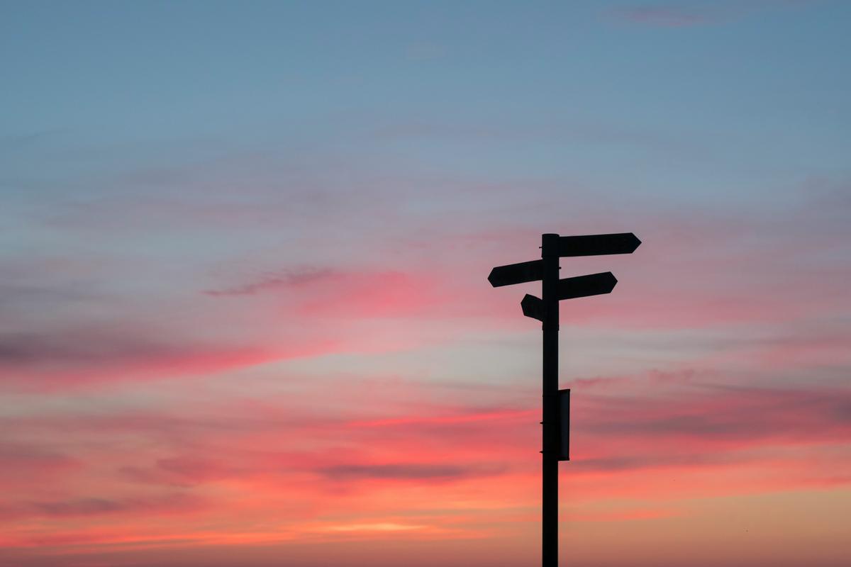 Silhouette of a road signpost against golden sky, representing how canonical tags point search engines to the correct page