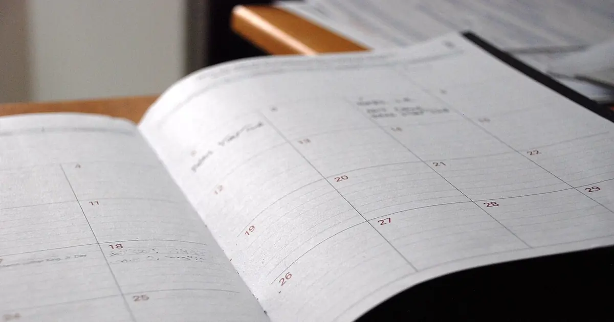 Open monthly calendar with handwritten notes, illustrating a 90-day SEO work plan