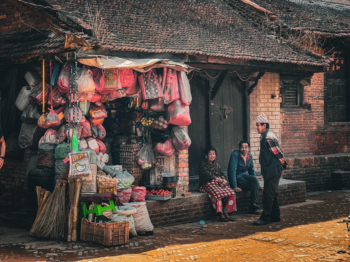 A Nepali market vendor at a colourful produce stall, a typical small local business