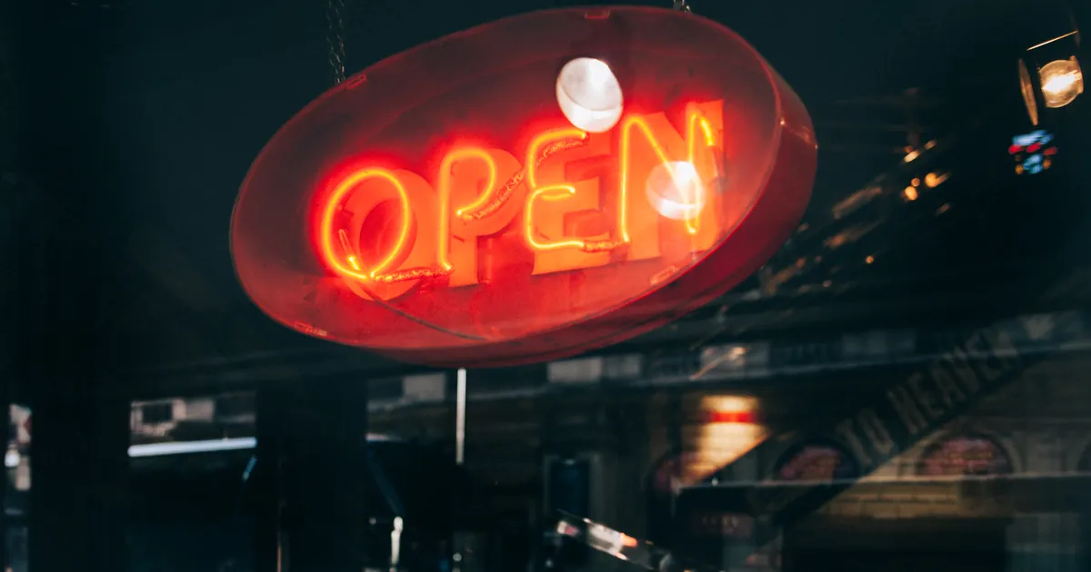 Illuminated OPEN sign in a shop window, representing a business that customers can find