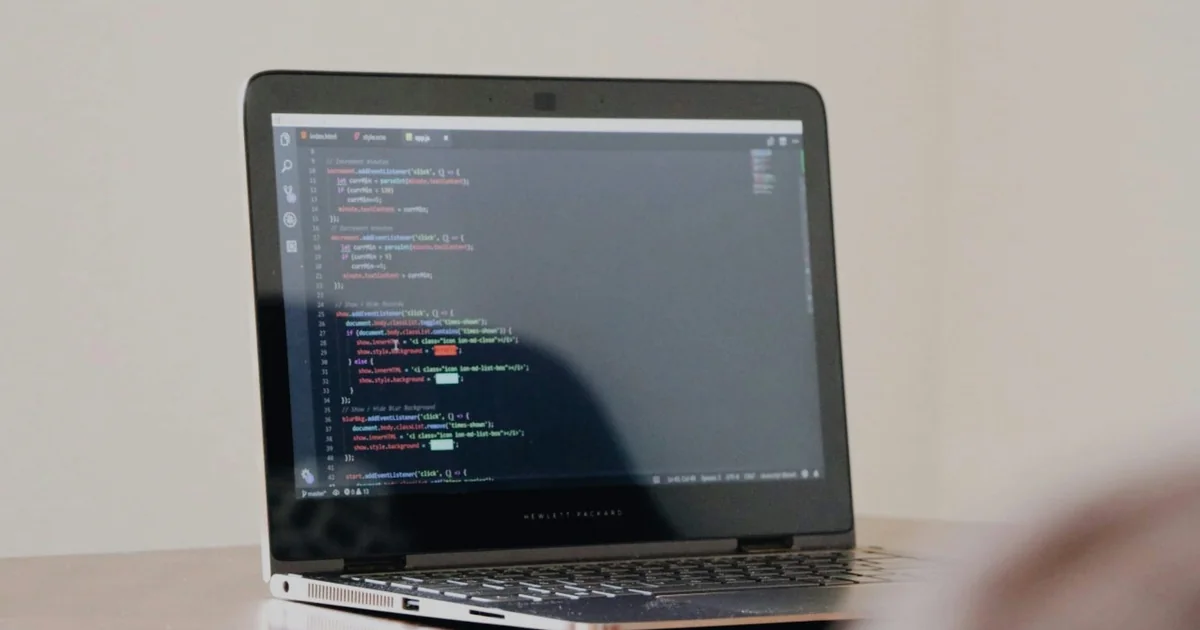 Laptop displaying source code on a desk, illustrating metadata debugging