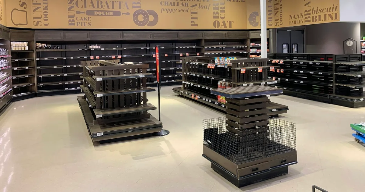 Mostly empty retail store shelves, illustrating unavailable product inventory.