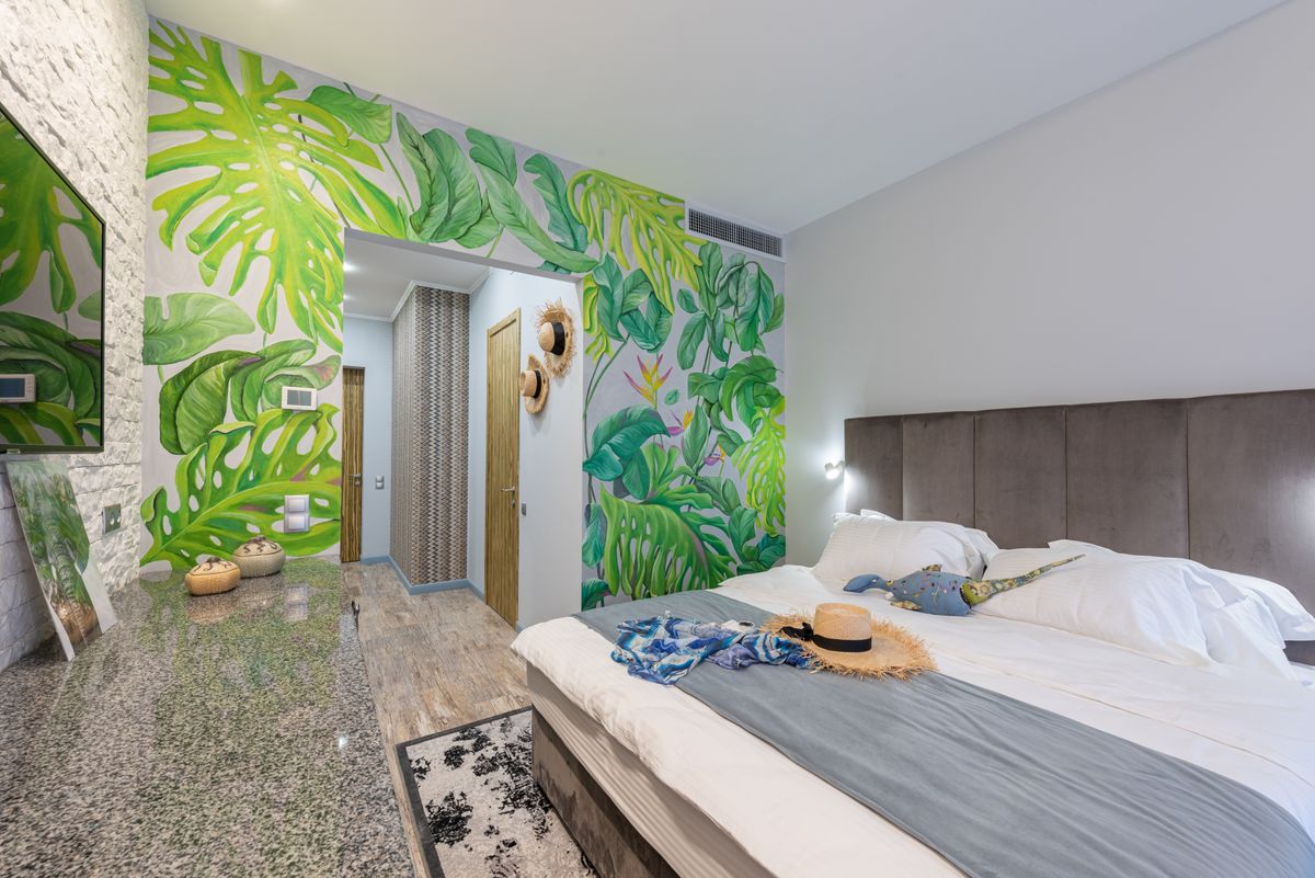 A bright, welcoming hotel room with a made bed and tropical décor, the kind of stay travellers book after searching on Google