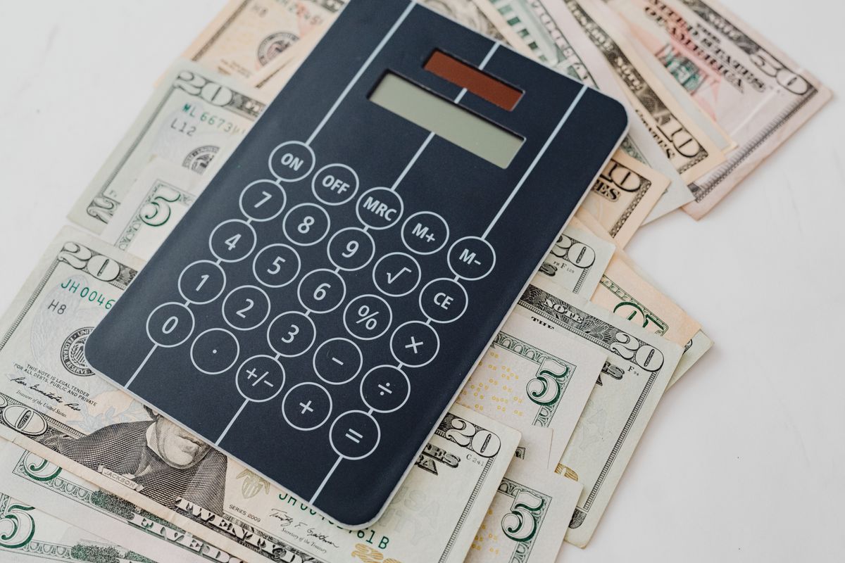A calculator and cash on a desk, representing SEO pay and salary in Nepal