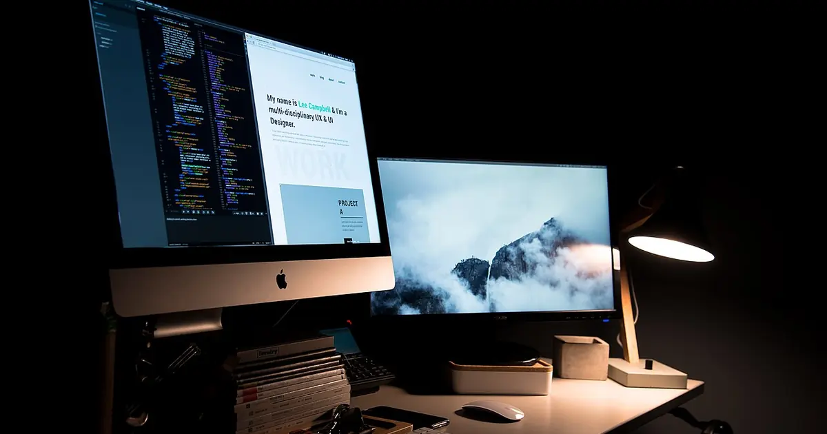 Two computer monitors on a designer's desk, illustrating service page planning and development
