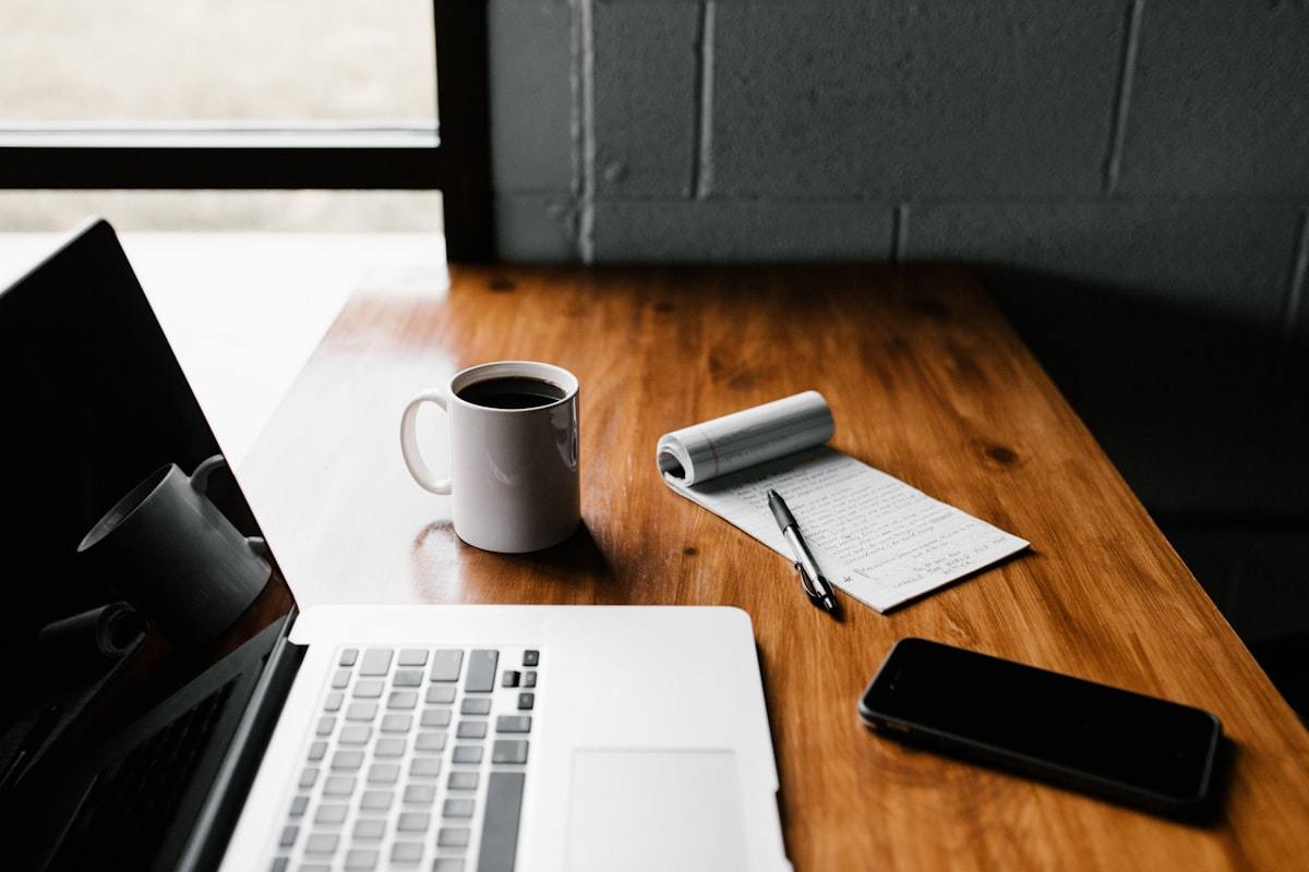 Laptop on a desk with a coffee cup, representing the process of writing optimized SEO title tags