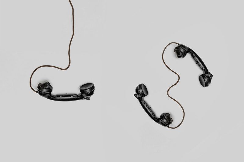 Two telephone handsets connected by cords, representing getting in touch