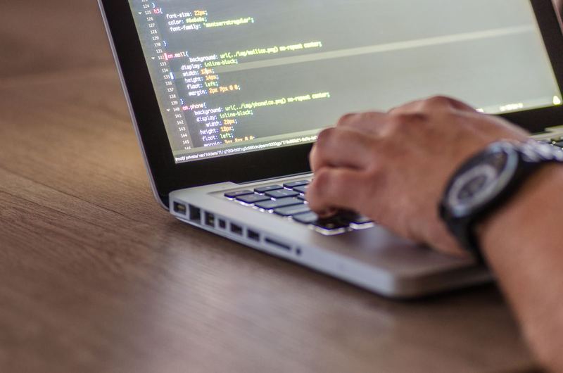 A modern developer workstation with code on screen and a backlit keyboard